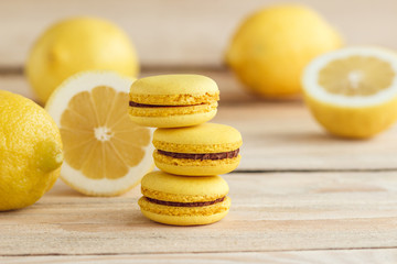 Yellow french macarons with lemons on the wooden board