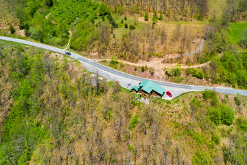 Building on the edge of the road in the forest, top view