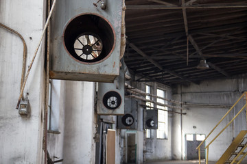 Interior of the old big abandoned factory, on the walls, broken air conditioning