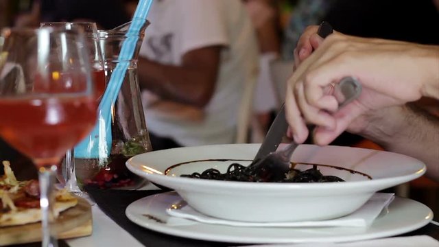 Italian restaurant table, black cuttlefish ink spaghetti pasta with shrimp eating
