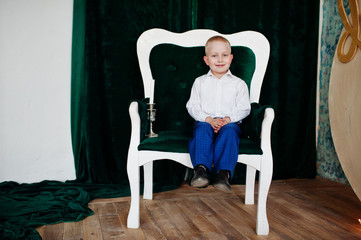 Portrait of an adorable little boy in official clothing posing with candlestick.