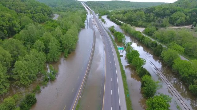 Aerial flight over an interstate highway that is covered by a flooded river