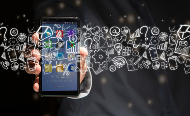 Hand of a man holding device with internet icons all around
