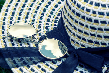 Summer hat with eyeglasses on fresh green grass.