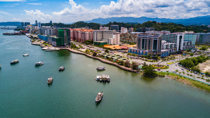 Kota Kinabalu city aerial view above sea level with boats berthing on the sea - obrazy, fototapety, plakaty