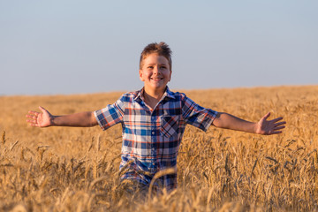 young boy running on ripe wheat field