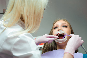 Female dentist examining teeth in dental office