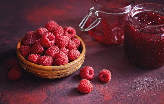Fresh raspberries and a jar of raspberry jam.
