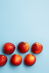 A few ripe nectarines on a blue background