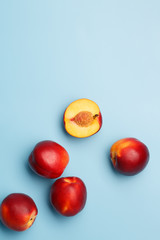 A few ripe nectarines on a blue background