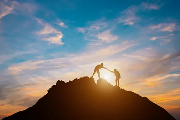Foto op Plexiglas  Silhouette of couple teamwork  hiker helping each other on top of mountain © Guitafotostudio
