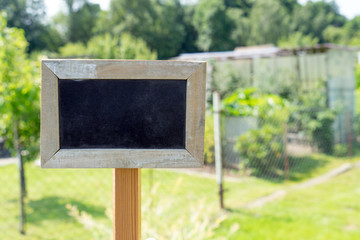 Schrebergarten / leeres Schild vor einem Gartengrundstück