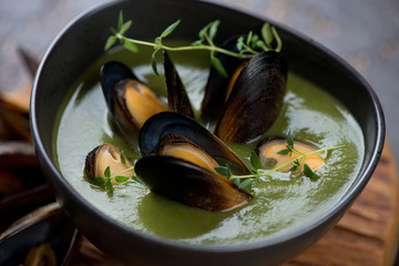 Close-up of spinach cream-soup with mussels, selective focus, horizontal shot