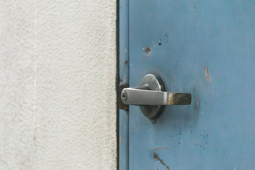 Old rusty door handle at blue door.