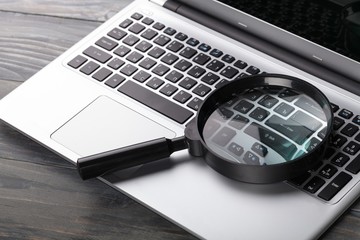 Laptop computer with magnifying glass.