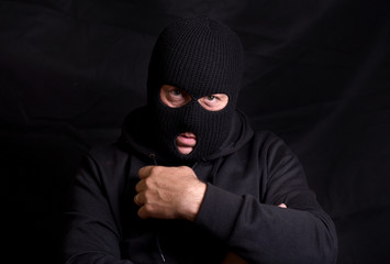 Horizontal image of a threatening man with a balaclava mask 