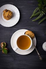 Herbal tea and homemade oatmeal nut cookies on a dark wooden background. Top view