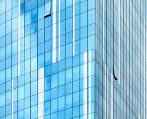 Fototapeta na wymiar Glass facade of modern building. Cloudy sky reflects in glass