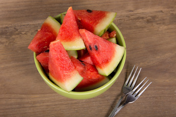 slices of watermelon on brown wooden background