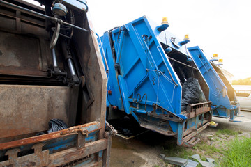 End of garbage truck parked in parking lot.