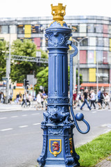 Old ancient blue pump of water with sculptures on it in Szczecin, Poland.
