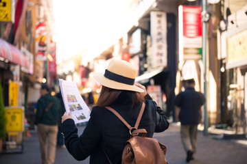 Woman tourist is looking travel mapping while traveling in Tokyo, Japan.