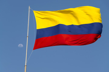Fototapeta na wymiar Colombian flag is streaming in the wind over the weathered walls of the fortress of Castillo San Felipe de Barajas in Cartagena de Indias, Colombia.