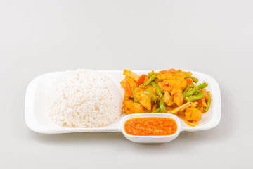Isolated Asian cuisine fried chicken with turmeric, onion, long bean, carrot and chili spicy sauce with steam rice