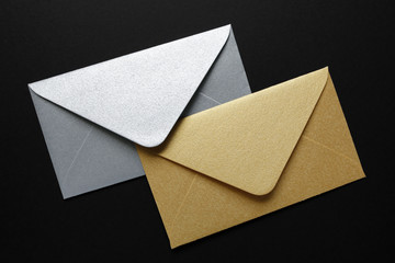 silver and gold envelopes on black background
