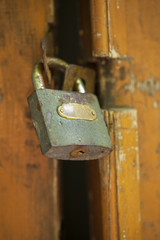 Old door with a lock. Old cracked paint on wooden wall. Grunge background