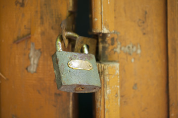 Old door with a lock. Old cracked paint on wooden wall. Grunge background