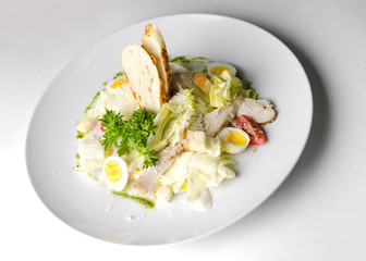 Mix salad with egg quail and croutons on a white plate
