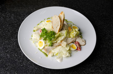 Mix salad with egg quail and croutons on a white plate