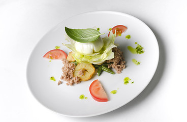 Mix salad with egg poached and tuna on a white plate