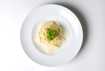 Spaghetti carbonara with bacon and cheese on a white plate