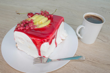 Sliced tasty cake and coffee on wooden table background. Cake with fresh red currant on the plate