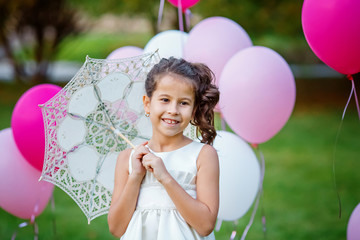 Portrait of charming little girl in a smart dress holding a white lace parasol