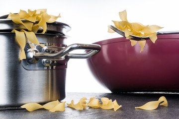 Bandnudeln, Pasta, Kochen, Topf, Nudeln und Bratpfanne, vor hellem Hintergrund auf Granittisch