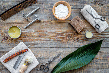 Barber workplace. Shaving brush, razor, foam, sciccors on wooden table background top view copyspace