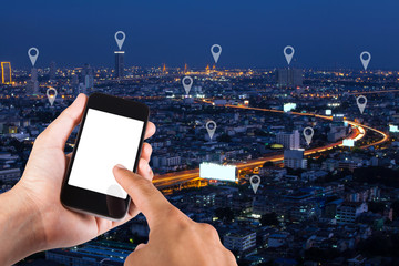 Man hand using smartphone searching location  on map pin on top view city scape in Bangkok, Thailand.