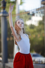 Young beautiful ballerina dancing outdoors in a park. Full length portrait.