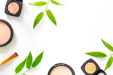 Makeup kit. Eyeshadows, brushes, blushes on white table background top view copyspace