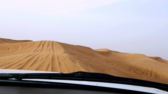 4x4 off road land vehicle taking tourists on desert dune bashing safari in Dubai, UAE