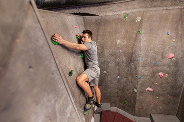 Fototapeta na wymiar young man exercising at indoor climbing gym