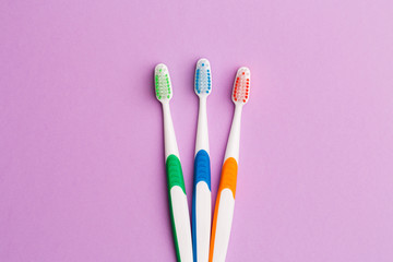 Photo of three multi-colored toothbrushes