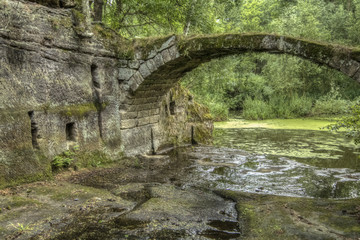 Fototapeta na wymiar Stone bridge by water