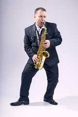 Fototapeta premium Melody saxophone. Man. European. He plays the saxophone. Dressed in a suit.