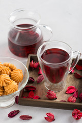 The cup with double glass with hibiscus tea is on a table.