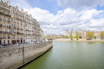 Fototapeta premium Seine River in Paris with the City Hall on the back and generic old historic parisian buildings on the front on a sunny spring day in this beautiful European city