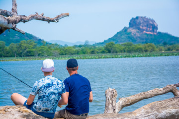 The tourists are fishing on the shore of Thalkote lake near Sigiriya In Sri Lanka